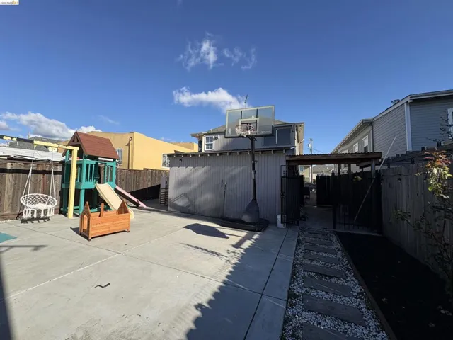 Fenced backyard with a playground and a​​‌​​​​‌​​‌‌​​‌​​​‌‌​​​‌​​‌‌​​‌‌​​‌‌​​​​ patio