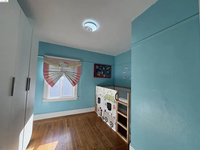 Bedroom featuring dark wood finished floors and baseboards