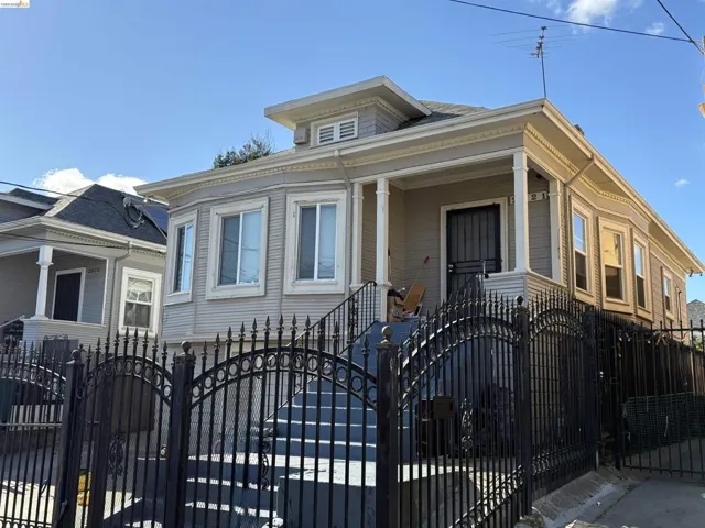View of front of house featuring a gate, a fenced front yard, and a porch