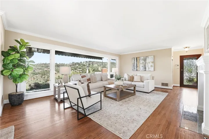 Hardwood flooring, crown moulding, large floor to ceiling windows, and custom glass front door!