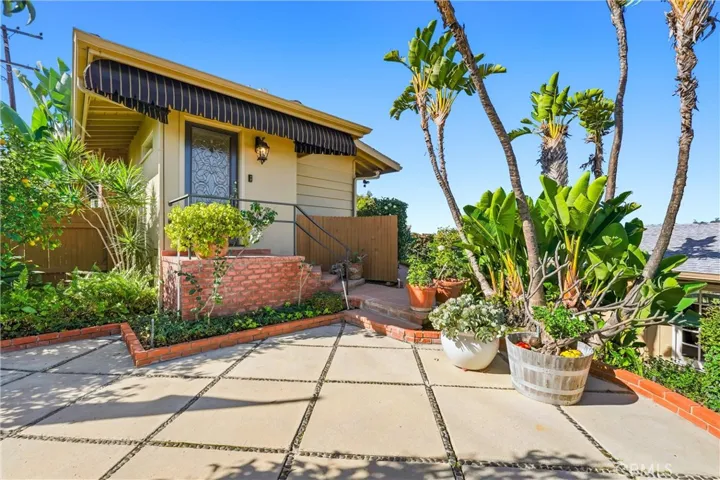 Front entry to the main house, large patio area is perfect for entertaining day or night! Surrounded by mature landscaping this space is an oasis from the busy day-to-day life!