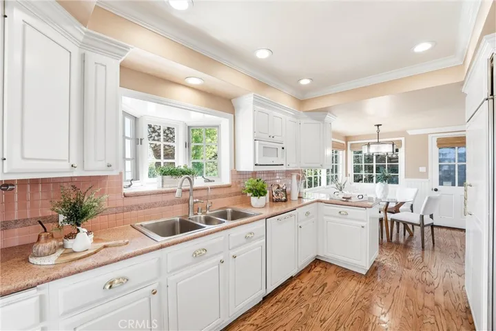 Kitchen with garden window, stainless steel sink, hardwood flooring, and ample cabinetry!