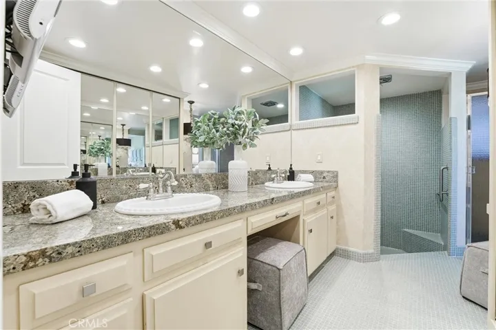 Primary En Suite with dual sinks, large walk-in shower, vanity area, and large closet.