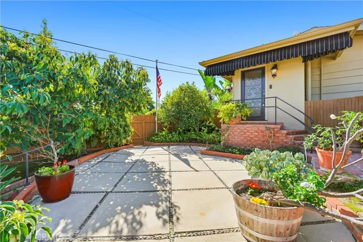 Upper patio area sits off the main entry to the home. Lushly landscaped, mature fruit trees that produce in excess throughout the year.