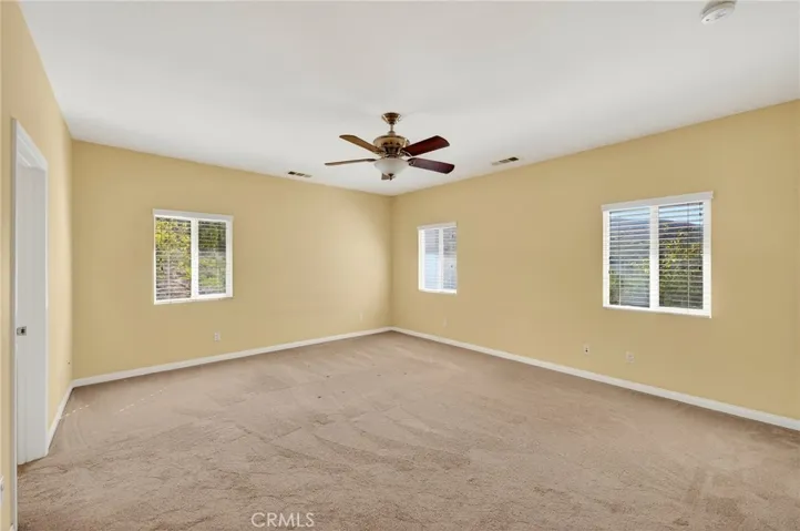 Primary Bedroom – With  room for a full furniture set and a ceiling fan, provides a flexible layout and peaceful backyard views.