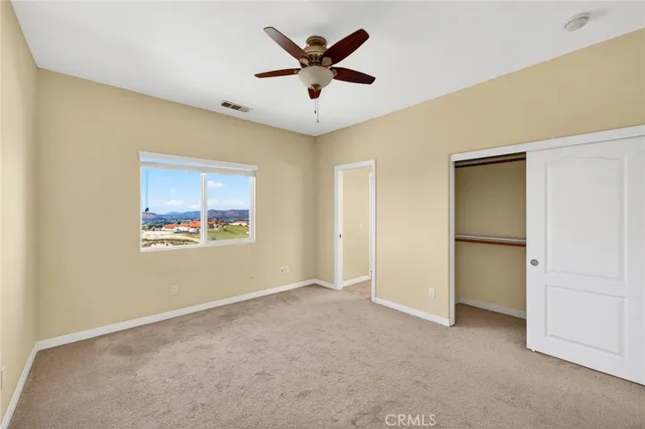 39475 Bruce Ln. bedroom1 soft neutral tones, carpet , ceiling fan, views to the hillside and valley