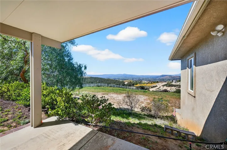 Relax under the shade of the covered patio while taking in sweeping views of rolling hills and distant mountains.