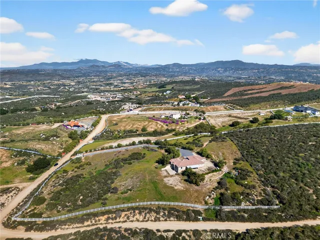 39475 Bruce Ln Aerial View – Elevated aerial perspective showcases the home’s private setting, generous lot size, and surrounding rolling hills.