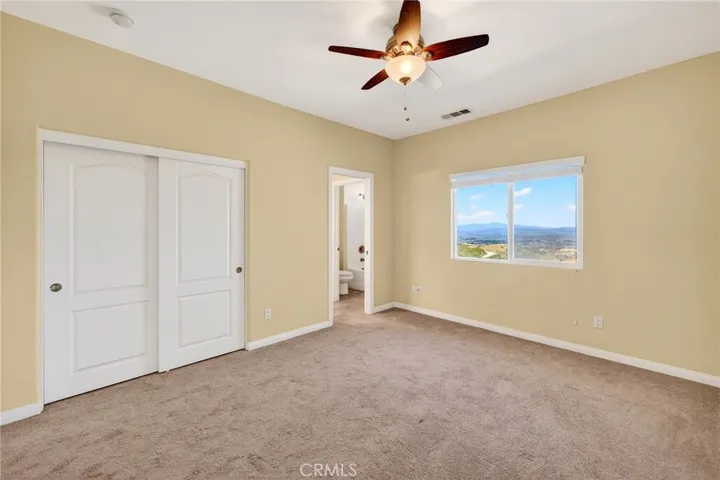 39475 Bruce Ln. bedroom 2 showcases neutral finishes,  carpet, and a ceiling fan, complemented  window with picturesque views.
