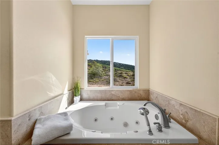  soaking tub set beneath a large  private window.