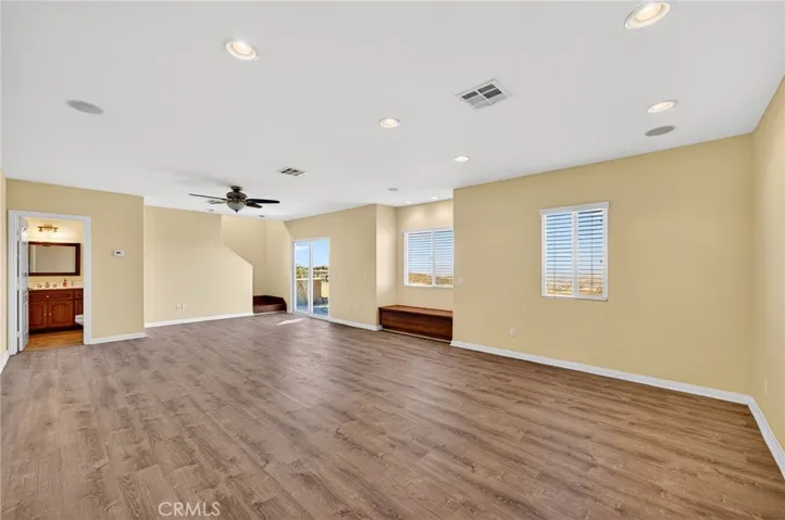Bonus Room / Lower-Level Living Area – This expansive lower-level space features wood-style flooring, recessed lighting, and a ceiling fan.