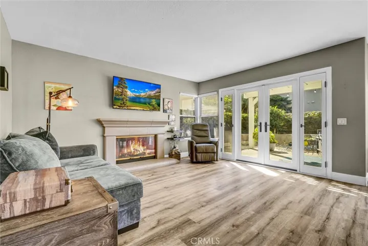 Family room with French doors to the back yard.  Fire in fireplace and flatscreen scenery have been digitally added.