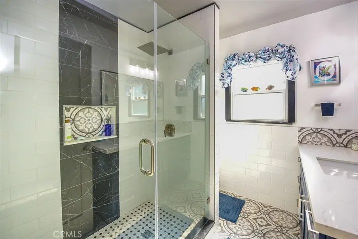 Guest bathroom with oversized shower. Custom tile, and glass, rain shower. Incredible style and timeless colors. Don't forget to notice the vanity and lighting!
