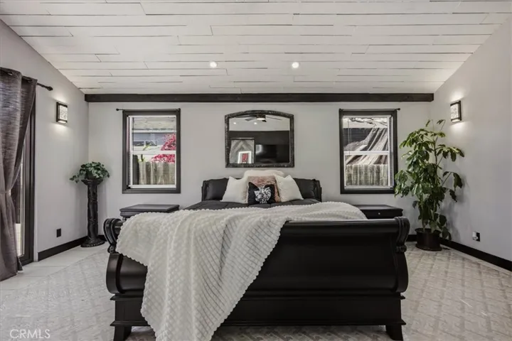 Primary bedroom with individual sconces fully opening glass door, make up vanity etc