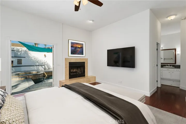 Spacious primary suite featuring tranquil pool views and abundant natural light