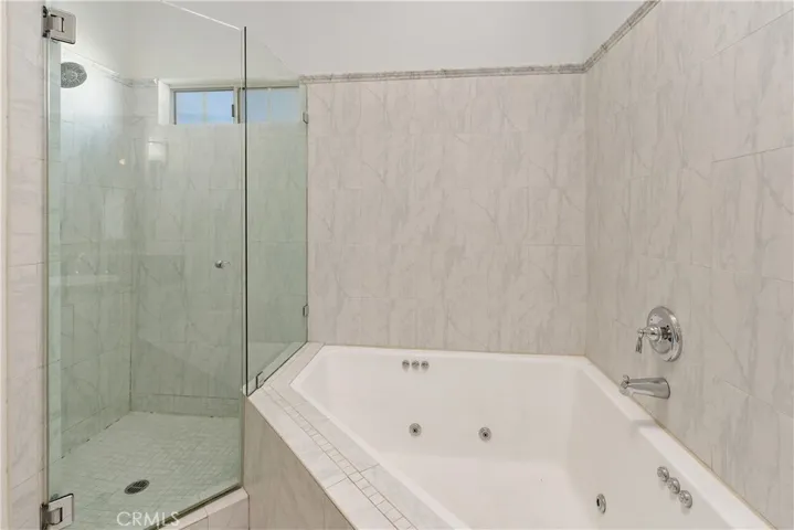 Primary bath featuring a soaking Jacuzzi tub plus separate walk-in shower for a true retreat feel