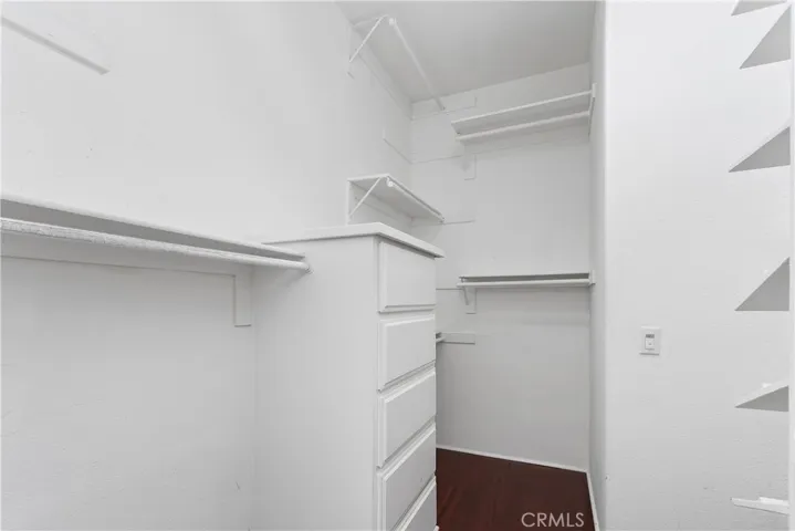 Large walk-in closet with built-in shelving and generous storage space
