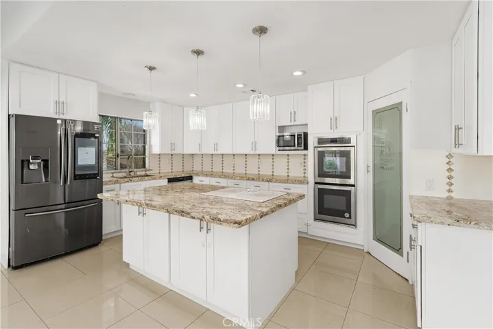 Updated kitchen featuring ample storage, long countertops, and bright, clean finishes