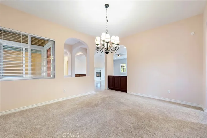 Large formal dine with chandelier is open to the entry & other entertaining spaces