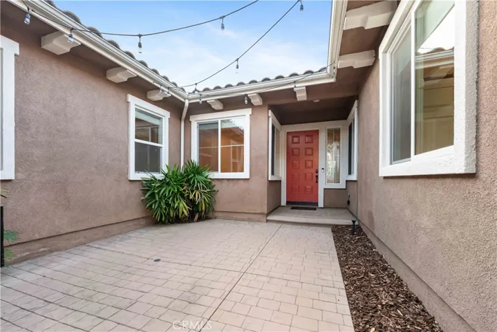 Front gated courtyard entrance with overhead lighting.