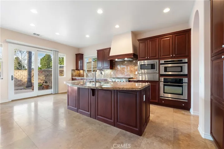 Cook's kitchen w/large center island with seating, Monogram appliances, loads of storage & a slider to the backyard.