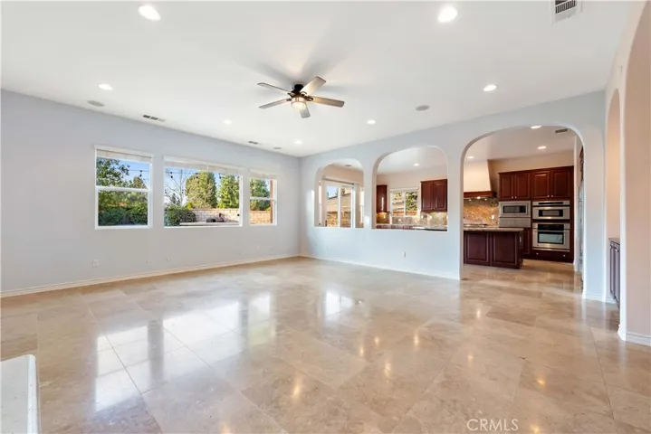 Large open great room with tile floor, view of the yard, recessed lighting & a ceiling fan