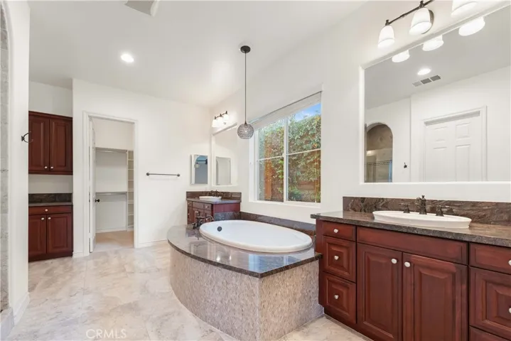 Primary bath with soaking tub, double sinks, gorgeous shower to the left of the tub & 2 walk-in closets