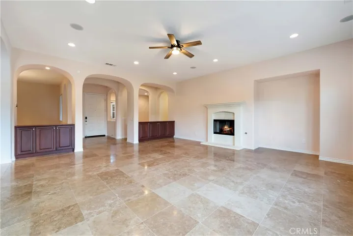The large, open great room has built-in cabinets, surround sound, recessed lighting, a fireplace & a tile floor.