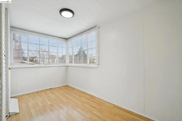 Unfurnished room featuring wood walls and light wood-type flooring