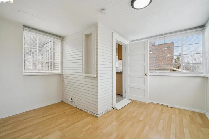 Empty room featuring light wood-style floors and healthy amount of natural light
