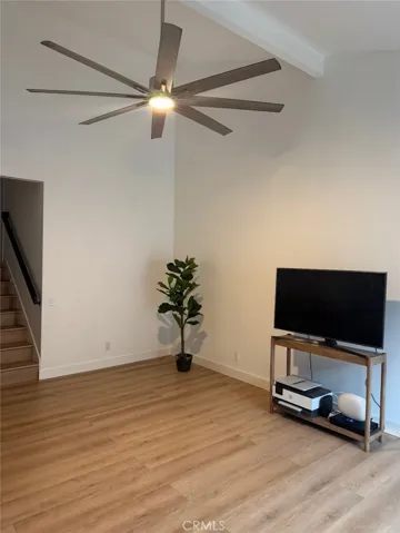 Living area with large ceiling fan & exposed beam