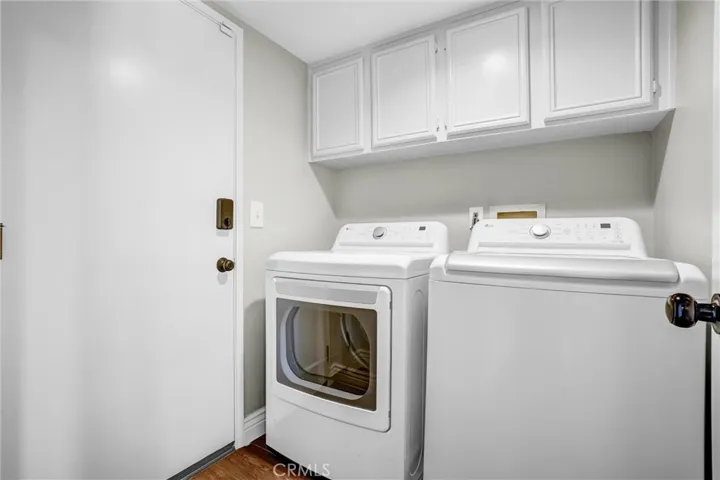 Dedicated laundry room with overhead storage cabinets and convenient interior access