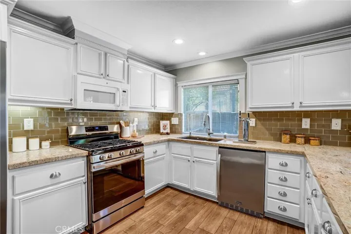 Bright kitchen with ample cabinetry, stainless steel appliances, and granite countertops