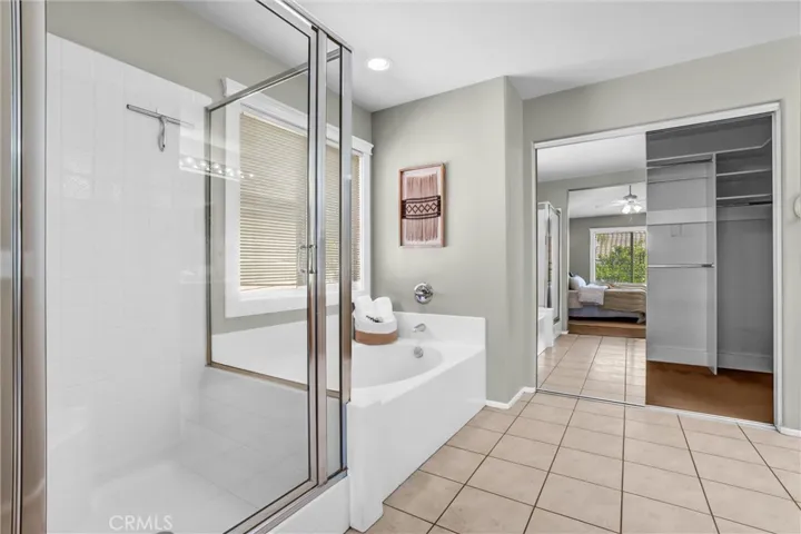 Primary bathroom featuring dual-sink vanity, tile flooring, and large mirror