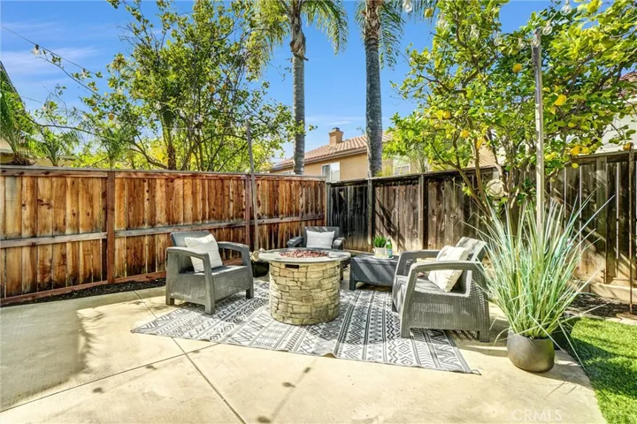 Dedicated outdoor lounge area with fire pit, surrounded by mature landscaping for privacy and comfort