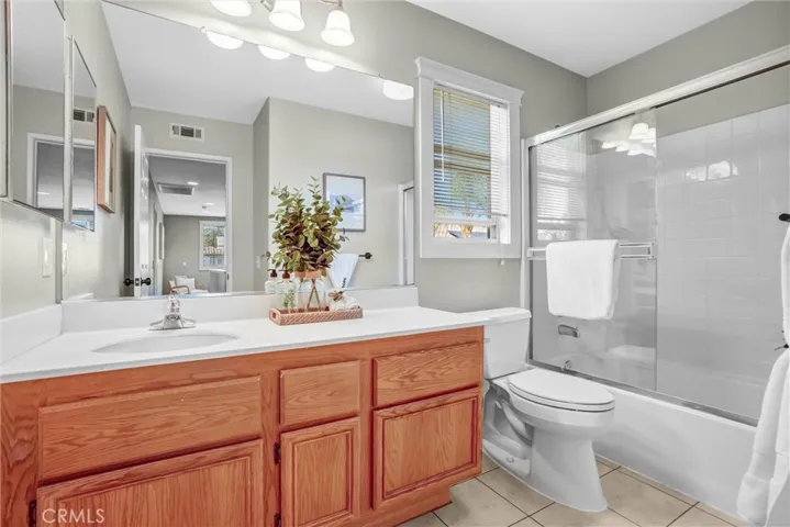 Full upstairs bathroom featuring ample counter space, tile flooring, and tub/shower combination