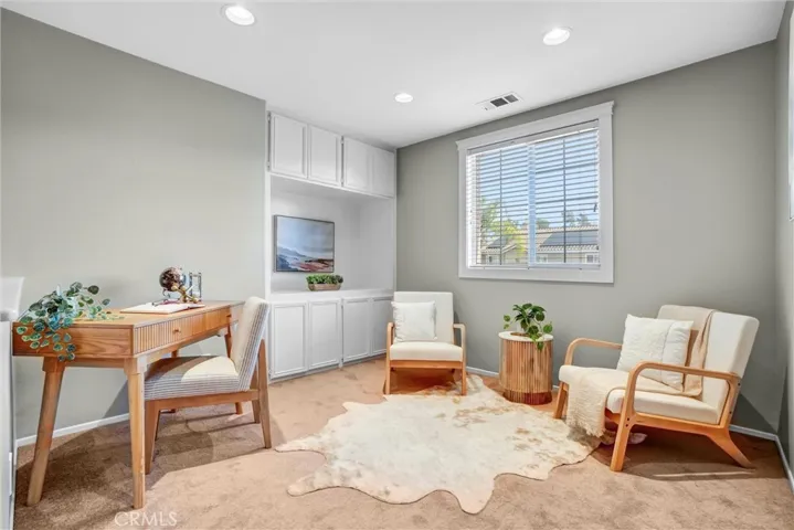 Versatile loft area perfect for a home office, reading nook, or homework station with built-in cabinetry