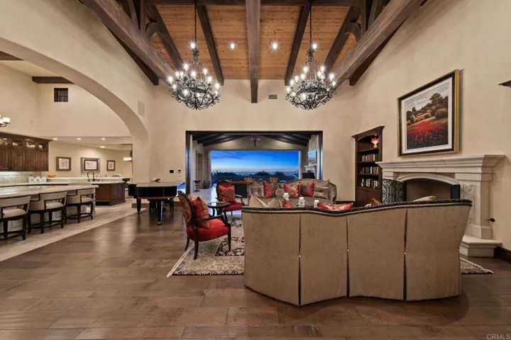Spacious entertaining area with built out book cases and vanishing slider doors.