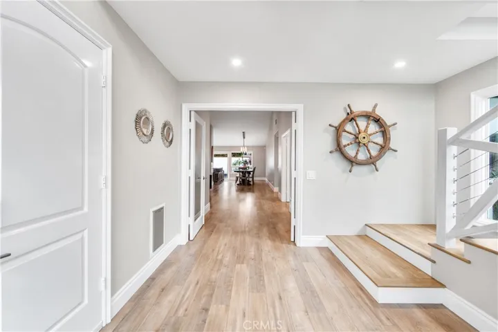 Bright connecting hallways lead to bedrooms while showcasing the striking glass entry and staircase.