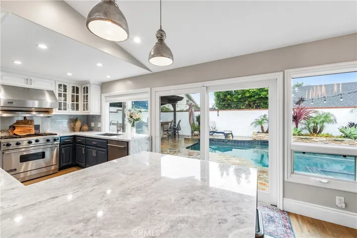 Spacious dining area with marble breakfast bar and views to the resort-style backyard