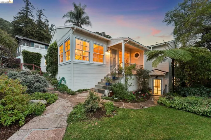 Bungalow featuring a lawn and stairway