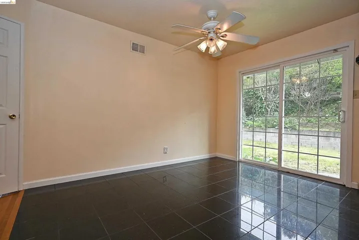 Empty room featuring baseboards and a ceiling fan