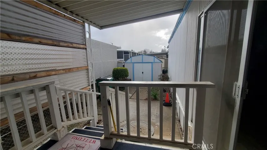 View of back porch area with shed in back yard.