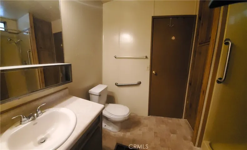 View of guest bathroom off laundry room with door leading to guest bedroom.