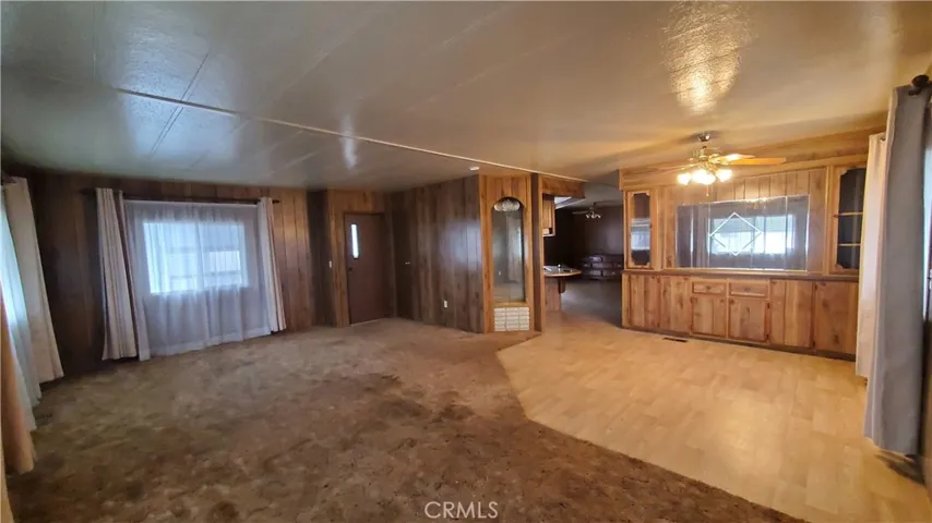 View of living room with front entry door and built in hutch cabinet area in dining room.
