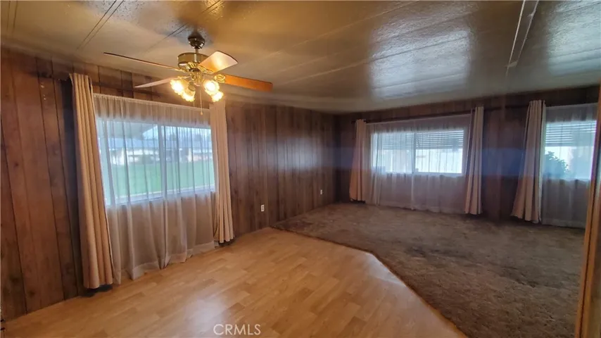 View of dining room area overlooking living room area with large windows.