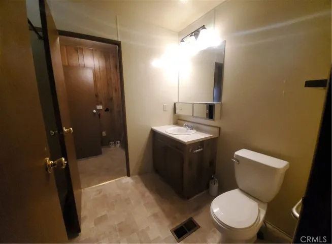 View of guest bathroom with door leading to laundry room.