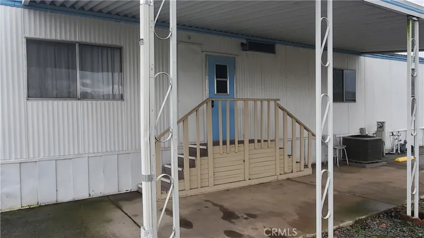 View of carport with stairs to back door leading to laundry room.