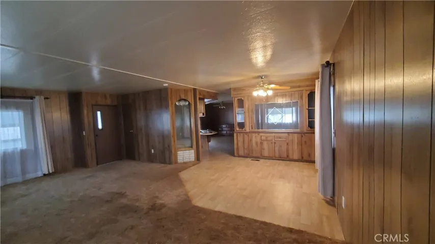 View of front entry door and living room carpet on the left & dining room area on the right.