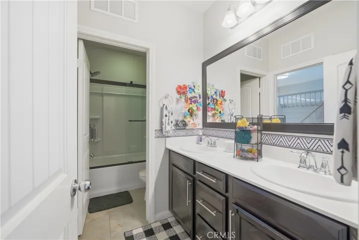 Shared bathroom with dual sinks.